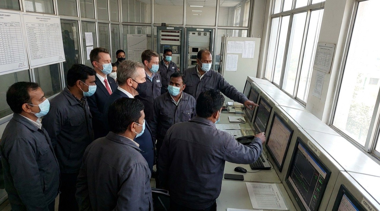 A control room at a nuclear facility with international inspectors reviewing monitoring screens.