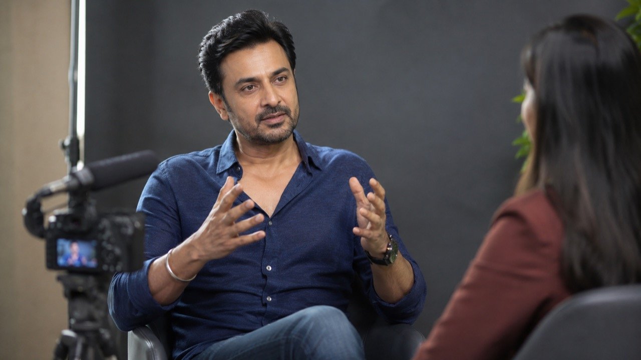 A veteran Indian television actor speaking candidly during a studio interview, framed by soft lights and a microphone